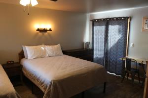 Habitación pequeña con cama y ventana en Columbine Inn, en Estes Park