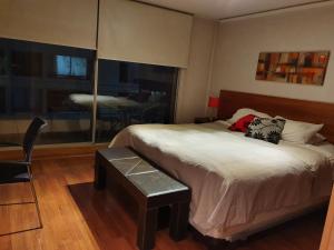 a bedroom with a bed and a table and a bedroom with a view at La Concepcion, Providencia Suites in Santiago +22 photos