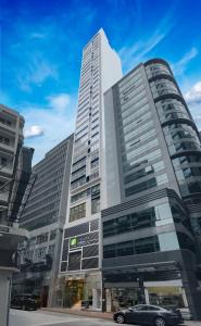 um edifício alto com um carro estacionado em frente em iclub AMTD Sheung Wan Hotel em Hong Kong