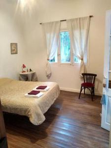 - une chambre avec un lit, une fenêtre et une chaise dans l'établissement la belle epoque, à San Antonio de Areco