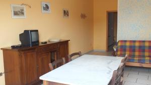 a dining room with a table and a tv on a cabinet at Vecchio Molino in Venturina Terme