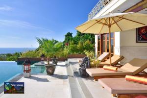 a pool with chairs and an umbrella next to a building at Villa Oscar in Temukus