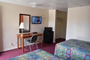 ein Hotelzimmer mit 2 Betten und einem Schreibtisch mit einem Computer in der Unterkunft PLYMOUTH MOTOR LODGE in Terryville
