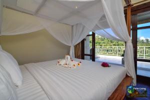 a bedroom with a bed with white sheets and flowers at Villa Oscar in Temukus