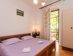 - une chambre avec un lit et 2 serviettes dans l'établissement Apartments Ivan - 50 m from sea, à Mali Lošinj