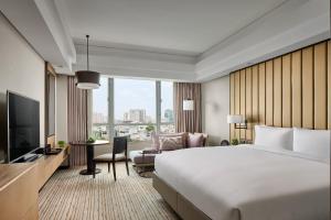a hotel room with a large bed and a large window at New World Saigon Hotel in Ho Chi Minh City