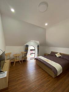 um quarto com uma cama e uma mesa com cadeiras em Marguerite Villa em Da Lat