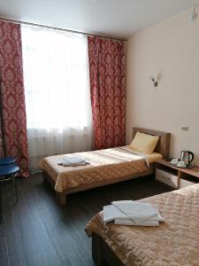 LesosibirskにあるЕнисейのベッド2台と窓が備わるホテルルームです。