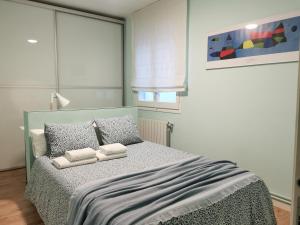 a bedroom with a bed with two towels on it at Dos habitaciones dobles en apartamento confortable in Hospitalet de Llobregat