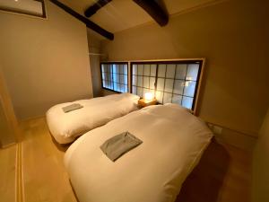two beds in a room with a window at CAMPTON Higashiyama Roku in Kyoto