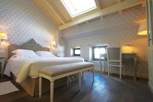 a bedroom with a large bed and a skylight at Las Doñas del Portazgo in Villafranca del Bierzo