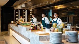 a group of chefs wearing masks in a restaurant kitchen at Holiday Inn Shanghai Nanjing Road by IHG in Shanghai