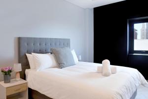 a bedroom with a white bed with a stuffed animal on it at City Explorer - 704 in Cape Town +21 photos