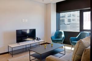 a living room with two chairs and a tv at City Explorer - 704 in Cape Town