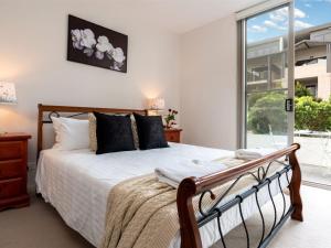 a bedroom with a bed and a large window at Blue Vista in Gerringong