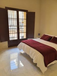 sypialnia z dużym łóżkiem i dużym oknem w obiekcie Habitaciones Casa Sevillana Centro w Sewilli