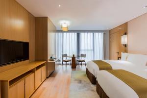 JiangningにあるHoliday Inn Nanjing Qinhuai South Suites, an IHG Hotelのベッド2台、薄型テレビが備わるホテルルームです。