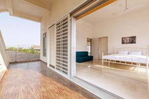 a bedroom with a bed and a large window at Casa Del Vento by StayVista - Villa showcasing a swimming pool, Terrace with deck & A lush lawn with a gazebo for a delightful stay in Lonavala
