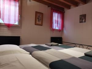 2 bedden in een kamer met rode ramen bij Apartment 6518 in Venetië