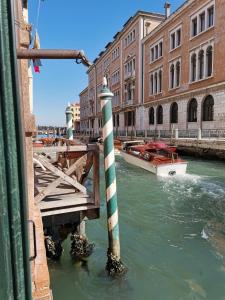 een boot in het water bij een dok met een paal in het water bij Apartment 6518 in Venetië