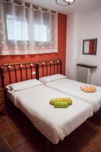 2 camas individuales en una habitación con paredes rojas en Casa Vacacional Torredano II en Nalda