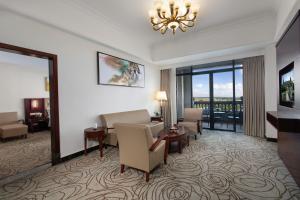 a hotel room with a waiting area with chairs and a chandelier at Wyndham Garden Haikou South in Haikou