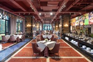 a restaurant with tables and chairs in a room at Wyndham Garden Haikou South in Haikou