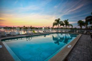 une grande piscine avec des chaises et des palmiers dans l'établissement 310 - Palms of Treasure Island, à St. Pete Beach