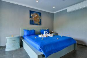 Un dormitorio con una cama azul con juguetes. en Villa Coco, en Temukus