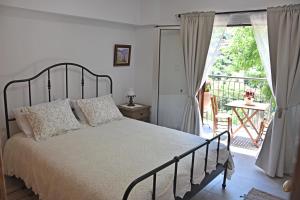 a bedroom with a bed and a balcony at The Old Coffeehouse in Kalopanayiotis