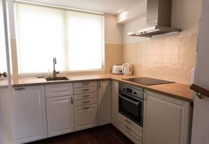 a kitchen with white cabinets and a sink and a window at Prinsen Apartment in Amsterdam