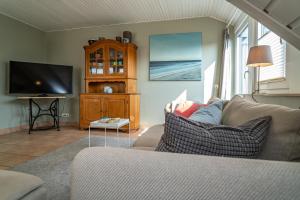 sala de estar con sofá y TV de pantalla plana en Perfekte Wohnung in perfekter Lage mit Balkon!, en Westerland