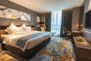 a hotel room with a bed and a television at Ames Hotel in Melaka