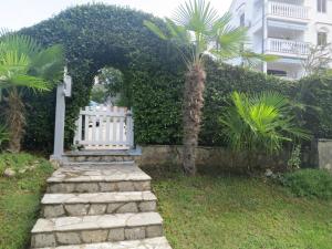 un jardín con una puerta blanca y una palmera en Apartment Prpic, en Malinska