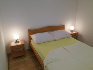 1 dormitorio con 1 cama con 2 lámparas en las mesas en Apartment Prpic, en Malinska