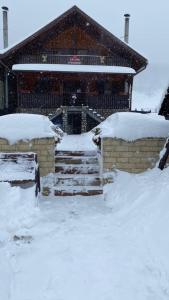 a house covered in snow with stairs and a building at Freemont in Braşov