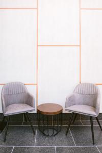 two chairs and a table in front of a wall at Indie Hotel Kuala Lumpur in Kuala Lumpur