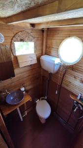 a small bathroom with a toilet and a sink at Dream catcher treehouse in Preveza