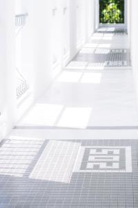 an empty hallway with white tiled floors and doors at Indie Hotel Kuala Lumpur in Kuala Lumpur