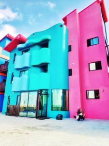 a pink and blue building next to a pink at Xingqing Seaview Homestay in Magong