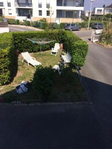 a park with two benches on the side of a street at Cosy's Olivier in Larmor-Plage
