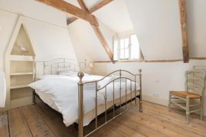una camera con letto di metallo e sedia di Driftwood Cottage pets go free WiFi included a Hunstanton