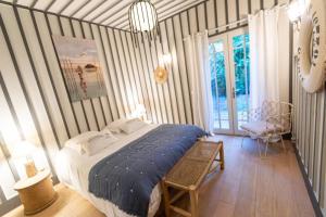 une chambre avec un lit et une chaise dedans dans l'établissement La Villa du Phare - 240 m² avec 5 chambres piscine, à Lège-Cap-Ferret