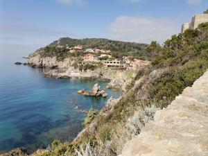 a view of a bay with houses on a cliff at Casa vacanze mare blu in Talamone
