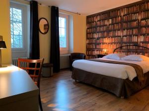 a bedroom with a large bed and bookshelves at AUBERGE DU PORCHE in Blaye