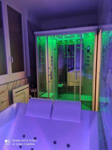 a bathroom with green lights in a room at L'étoile et le Merveilleux 2 appartements SPA in Dijon