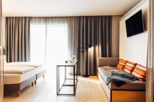 pokój hotelowy z łóżkiem i kanapą w obiekcie harry's home hotel & apartments w mieście Steyr