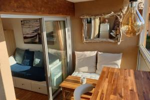 Zimmer mit einem Tisch, einem Bett und einem Spiegel in der Unterkunft FACE MER ENTRE PLAGE ET MARINA in Bormes-les-Mimosas