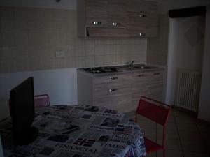 cocina con mesa, fogones y fregadero en Appartamento Sonia, en Thiene