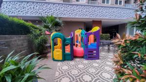 a colorful play set sitting outside of a house at Remarkable Studio at Baileys City Apartment By Travelio in Pondokcabe Hilir